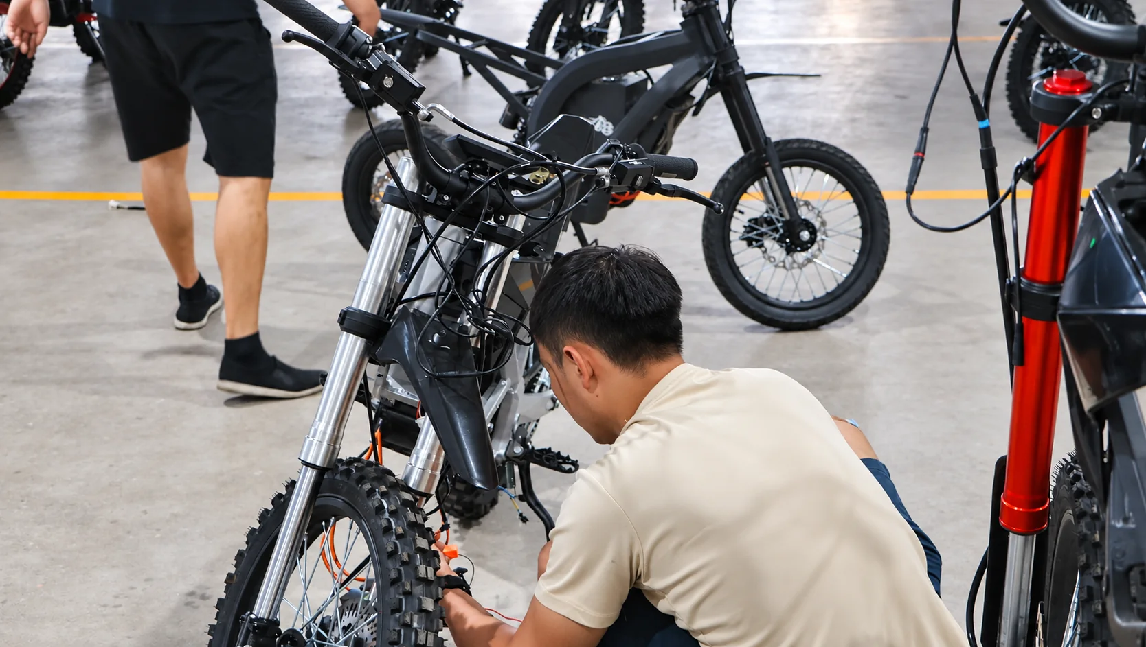 KMS technician inspecting an electric motorcycle during assembly